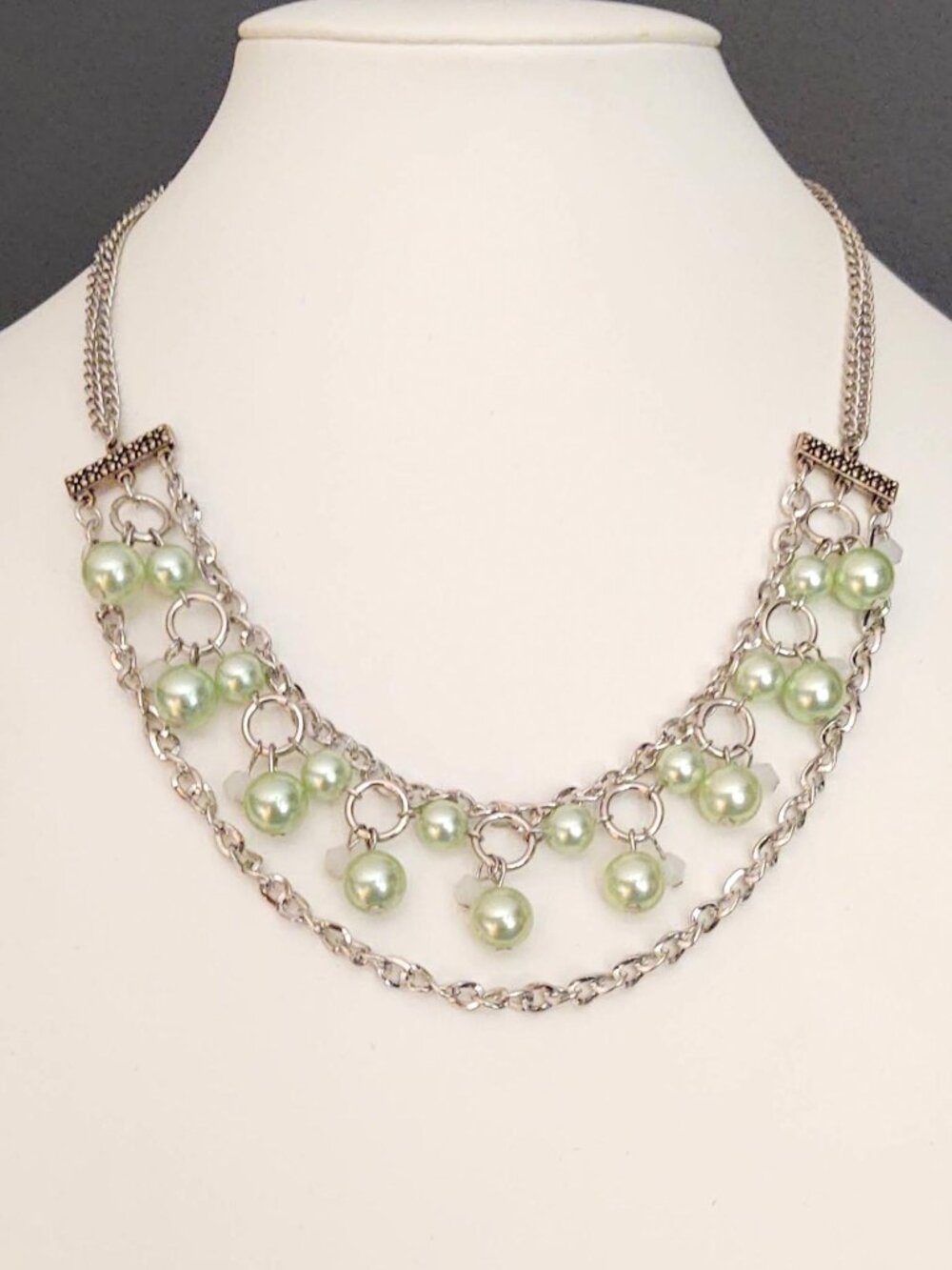 Silver necklace with green beads and white accents